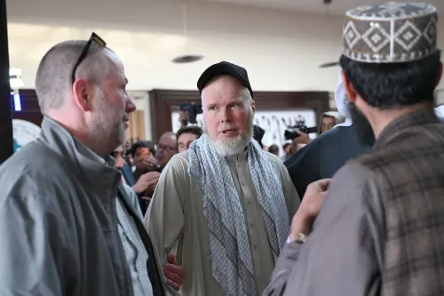 دينيس كويل، الأكاديمي الأمريكي المفرج عنه بعد أكثر من عام من الاحتجاز في أفغانستان، يتحدث مع مسؤولين في مكان عام.