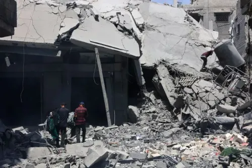 دمار هائل في مبنى نتيجة القصف، مع أشخاص يتجولون بين الأنقاض في منطقة متضررة، مما يعكس آثار الصراع في غزة.