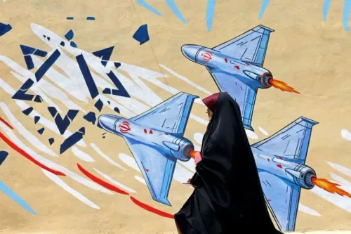 امرأة ترتدي الحجاب تسير أمام جدارية تظهر طائرات حربية إيرانية تطلق صواريخ، تعبيراً عن التوترات العسكرية والسياسية الحالية.