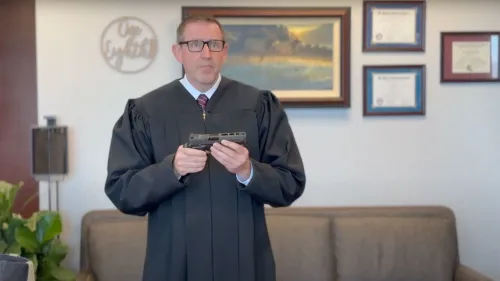 قاضي يحمل مسدسًا في مكتبه، معلقًا على قانون كاليفورنيا بشأن مخازن الأسلحة ذات السعة الكبيرة، في سياق جدل قانوني حول سلامة الأسلحة.