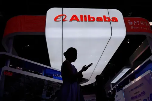 شخصية واقفة أمام شعار شركة Alibaba في معرض، تعكس التوترات بين الولايات المتحدة والصين بعد إدراج الشركة في قائمة البنتاغون للشركات العسكرية الصينية.