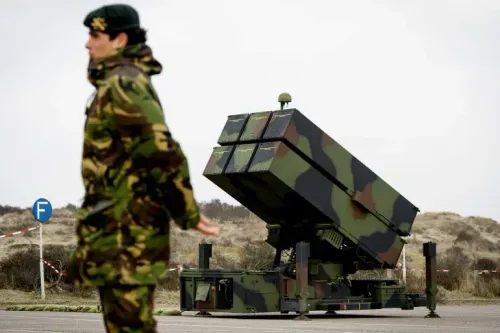 جندي يرتدي زيًا عسكريًا يقف بجوار نظام صواريخ أرض-جو متقدم (NASAMS)، وذلك في إطار صفقة تسليح محتملة لمصر.