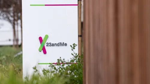 لافتة شركة 23andMe تظهر شعارها الملون في منطقة خضراء، تعكس الجدل حول بيع البيانات الجينية بعد إعلان إفلاسها.