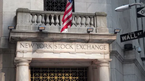 واجهة بورصة نيويورك مع العلم الأمريكي، تعكس التوترات الاقتصادية بعد فرض رسوم جمركية جديدة على السلع.