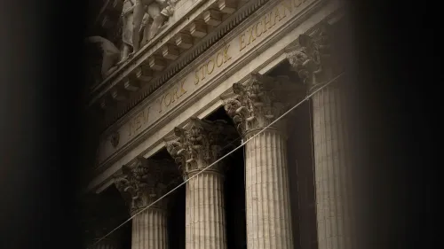 واجهة بورصة نيويورك مع أعمدة معمارية بارزة، تعكس تأثير الرسوم الجمركية على الأسواق المالية الأمريكية.