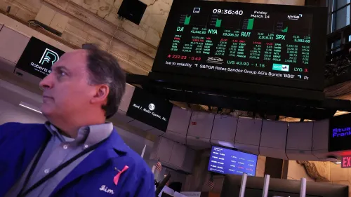 ارتفاع الأسهم الأمريكية يوم الجمعة مع تزايد معنويات المستثمرين، يظهر تاجر في بورصة نيويورك أمام شاشة تعرض مؤشرات الأسواق.