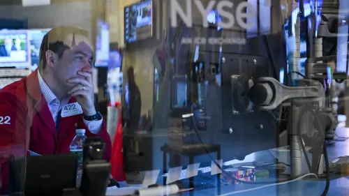 متداول في بورصة نيويورك يظهر تعبير القلق أثناء متابعة السوق، مع شاشات تعرض بيانات الأسهم والأخبار الاقتصادية.