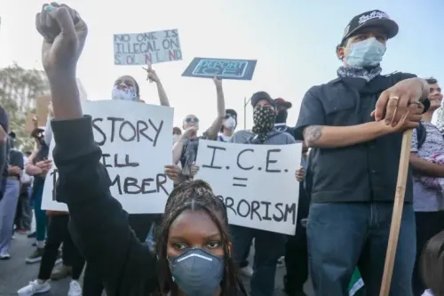 احتجاجات في لوس أنجلوس ضد سياسة ترامب المناهضة للهجرة، مع متظاهرين يحملون لافتات تعبر عن معارضتهم لإجراءات الهجرة.