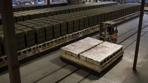 زيادة في معدلات التضخم تظهر من خلال ارتفاع مؤشر أسعار المنتجين، مع شاحنة نقل تعمل بين صناديق المنتجات في مستودع.