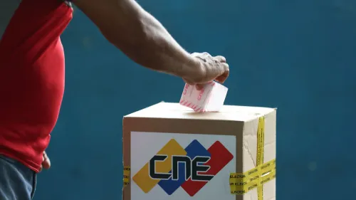 ناخب فنزويلي يضع صوته في صندوق الاقتراع خلال الانتخابات في منطقة إيسيكويبو، وسط توترات سياسية بشأن الإقليم الغني بالنفط.