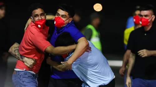 أشخاص يحتضنون بعضهم في مطار سيمون بوليفار الدولي بعد عودة المهاجرين الفنزويليين المفرج عنهم من السلفادور، مع مشاعر الفرح والتوتر.