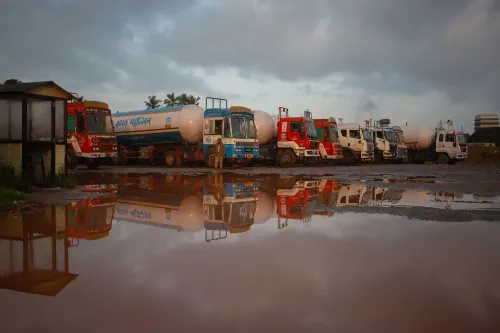 شاحنات نقل النفط متوقفة في موقع مبلل، تعكس الأجواء الغائمة، مما يعكس التحديات التي تواجه الهند في تأمين إمدادات النفط البديلة.