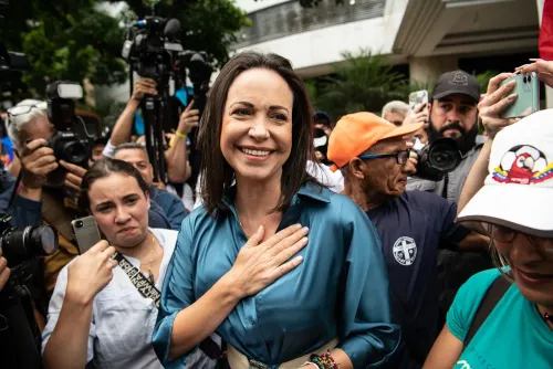 ماريا كورينا ماتشادو، زعيمة المعارضة الفنزويلية، مبتسمة وسط حشد من الصحفيين والمناصرين، تعبر عن شكرها خلال حدث عام.