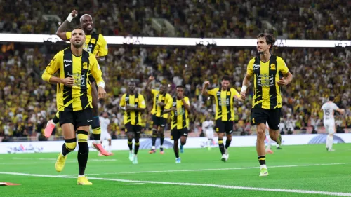 لاعبو الاتحاد السعودي يحتفلون بهدف في مباراة الدوري السعودي ضد الاتفاق، مع حضور جماهيري مكثف في الملعب.