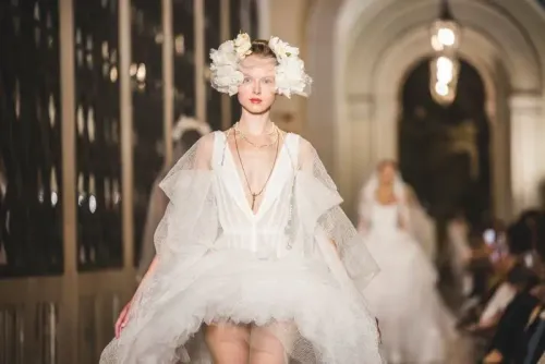 عارضة أزياء ترتدي فستان زفاف مبتكر من تصميم فيفيان ويستوود، مع زينة رأس من الزهور، أثناء عرض أزياء في برشلونة.