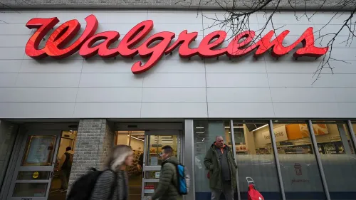 واجهة متجر Walgreens مع شعار الشركة البارز، بينما يتجول العملاء في الخارج، في سياق تسوية قانونية حول وصفات المواد الأفيونية.