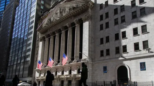 واجهة بورصة نيويورك مع أعلام أمريكية، تعكس النشاط المالي القوي وتزايد المكافآت في وول ستريت لعام 2024.