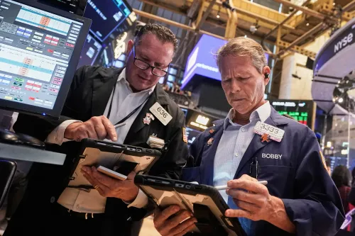 تجار في بورصة نيويورك يتابعون الأسهم ويحللون البيانات المالية، وسط تفاؤل بشأن خفض أسعار الفائدة وتأثيره على السوق.