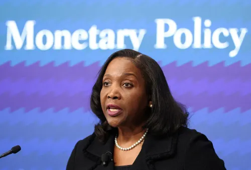 امرأة تتحدث في مؤتمر حول السياسة النقدية، مع خلفية تحمل عبارة "Monetary Policy"، تعكس أهمية دورها في الاحتياطي الفيدرالي.