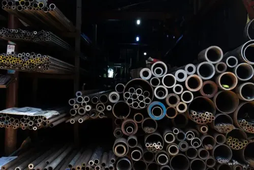 أنابيب معدنية متنوعة موضوعة في مستودع، تعكس تأثير التعريفات الجمركية على التجارة، مع تراجع صادرات كوريا الجنوبية.