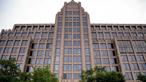 مبنى صحيفة واشنطن بوست يظهر من الأسفل، مع نوافذ كبيرة وأشجار في المقدمة، مما يعكس التوترات الداخلية بعد إعلان جيف بيزوس عن تغييرات تحريرية.