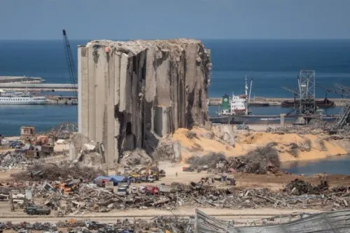 بقايا صوامع مرفأ بيروت مدمرة جزئياً وسط أنقاض الانفجار الذي وقع في أغسطس 2020، مع رؤية البحر في الخلفية.