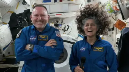 يظهر رائدا الفضاء سوني ويليامز وبوتش ويلمور في محطة الفضاء الدولية، يبتسمان ويتحدثان، مع أدوات فضائية خلفهما.