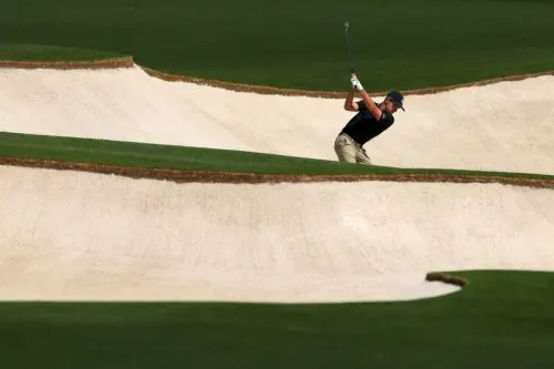 لاعب جولف شاب يتدرب في ملعب أوجوستا الوطني، محاطًا بالرمال والحدائق الخضراء، استعدادًا لبطولة الماسترز.