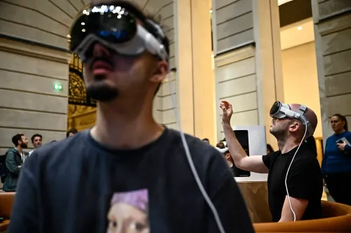 تجربة مستخدمين يرتدون نظارات واقع افتراضي في حدث تقني، مع تفاعلهم مع التكنولوجيا الحديثة في بيئة داخلية.