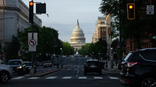 مشهد لشارع يطل على مبنى الكابيتول الأمريكي، مع حركة مرور خفيفة وإشارات مرورية، يعكس النشاط السياسي في واشنطن.