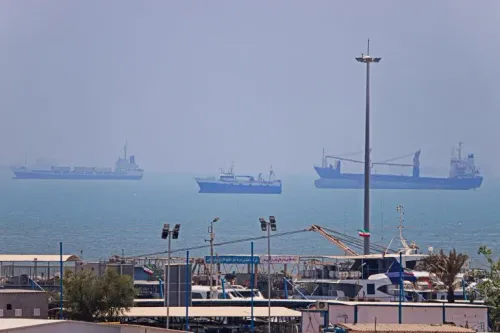 سفن شحن كبيرة راسية قبالة الموانئ الإيرانية الجنوبية في مضيق هرمز وسط تصعيد الحصار البحري الأمريكي وتأثيره على صادرات النفط الإيراني.