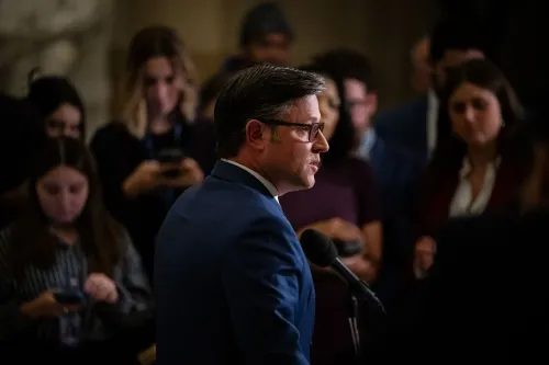 تظهر الصورة أحد المشرعين يتحدث في الكابيتول، محاطًا بالصحفيين. تتعلق الصورة بالجدل حول بند قانوني يتيح للمشرعين مقاضاة الحكومة.