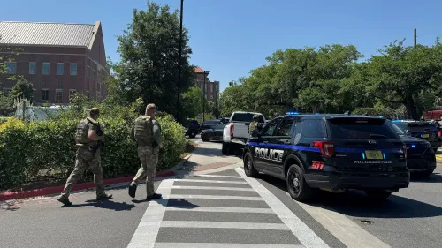 تظهر الصورة عناصر من الشرطة يرتدون زيًا عسكريًا أثناء استجابة لحادث في جامعة ولاية فلوريدا، مع وجود سيارات الشرطة في الخلفية.