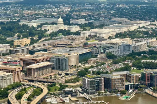 منظر جوي لواشنطن العاصمة يظهر مباني الحكومة الفيدرالية، بما في ذلك مبنى الكابيتول، مع التركيز على التحديات المرتبطة بإغلاق الحكومة.