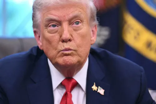 تعبير جاد للرئيس الأمريكي دونالد ترامب أثناء اجتماع في البيت الأبيض، مع خلفية تحمل رموز حكومية، يعكس التوترات السياسية حول خطط الإقالات الجماعية.