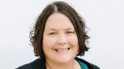 إيمي غليسون، القائمة بأعمال مدير دائرة الكفاءة الحكومية الأمريكية، تبتسم في صورة رسمية، تعكس خلفيتها المهنية في الرعاية الصحية.