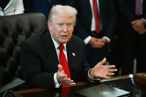 ترامب يتحدث بجدية خلال اجتماع، مع التركيز على قضايا الاقتصاد، وسط مستشارين في الخلفية. تعكس تعابيره إحباطه من ردود فعل الأمريكيين.