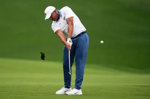 جوناتان فيجاس أثناء تسديد ضربة جولف، يظهر تركيزه على الكرة بينما تتطاير قطع من العشب، في سياق بطولة PGA.