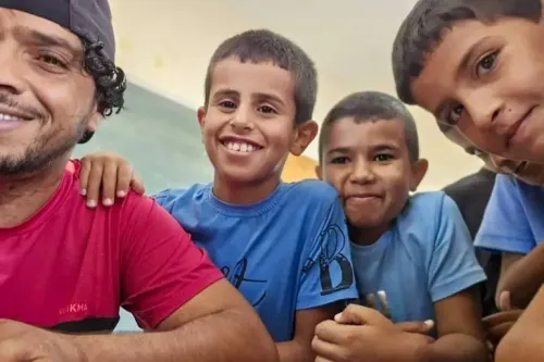 عودة الهذالين مع ثلاثة أطفال مبتسمين، في لحظة تعكس حبه وعلاقته القوية معهم، في سياق مقاومة الاحتلال في مسافر يطا.