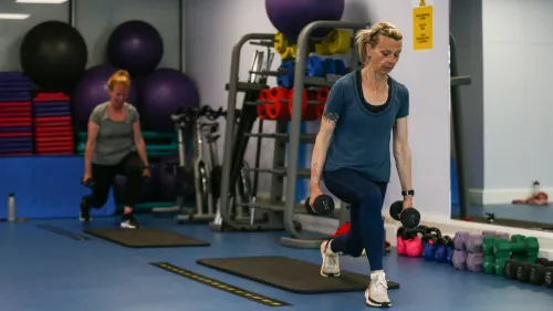 امرأتان تمارسان التمارين الرياضية في صالة رياضية، مع تركيز على أهمية النشاط البدني لصحة القلب.