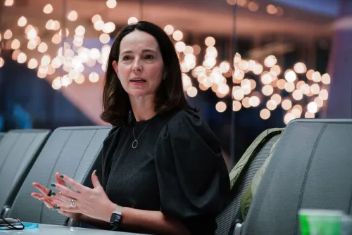 سارة فريار، المديرة المالية لشركة OpenAI، تتحدث خلال حدث، مع خلفية مضيئة، تعبر عن قلقها بشأن الدعم الحكومي لاستثمارات الذكاء الاصطناعي.