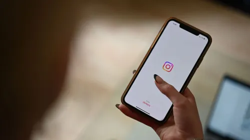 شخص يحمل هاتفًا يظهر شاشة تطبيق إنستجرام، مع التركيز على الشعار. يعكس الصورة التفاعل مع قضايا إلغاء المتابعة في وسائل التواصل الاجتماعي.