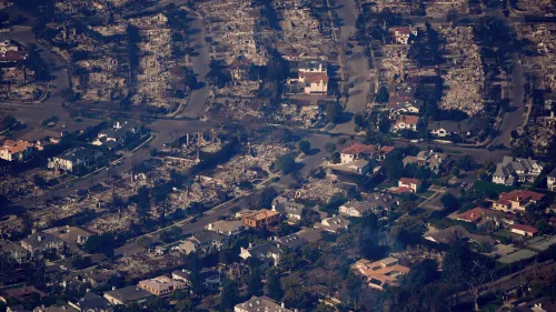 منظر جوي يظهر حيًّا بعد حريق، حيث دُمِّر العديد من المنازل، بينما بقي منزل واحد سليمًا وسط الدمار.