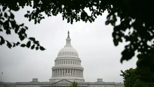 قبة مبنى الكابيتول الأمريكي محاطة بأشجار، تحت سماء غائمة، تعكس التركيز على التحديات التشريعية الراهنة في مجلس الشيوخ.