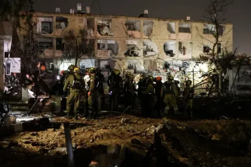 موقع دمار واسع في مدينة ديمونا الإسرائيلية بعد هجوم، مع وجود فرق الإنقاذ في الموقع. تعكس الصورة الأثر المدمر للصراع في المنطقة.