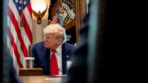 ترامب يجلس في غرفة الاجتماعات بالبيت الأبيض، مع العلم الأمريكي خلفه، أثناء مناقشة سياسة المواطنة بالميلاد.