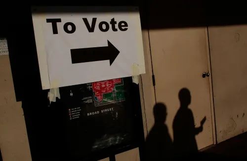 علامة تشير إلى اتجاه الاقتراع مع سهم يشير إلى اليمين، وظلال شخصين في الخلفية، تعكس أهمية المشاركة في الانتخابات.