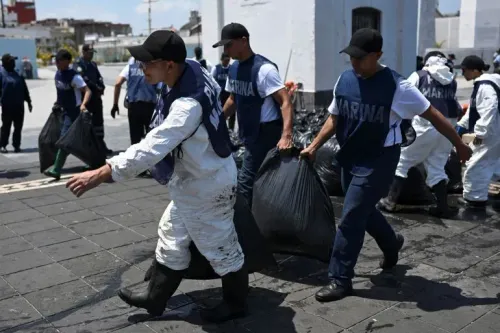 عمال يرتدون زيًا خاصًا يجمعون أكياسًا من الزيت خلال جهود تنظيف التسرب النفطي في خليج المكسيك، وسط مخاوف بيئية.