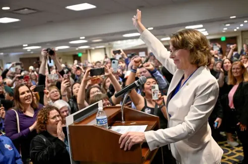 سوزان كروفورد، المرشحة الديمقراطية، تحتفل بفوزها في تجمع حاشد، حيث ترفع يدها وسط حشد من المؤيدين الذين يحملون الهواتف.