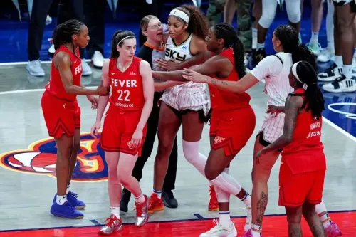 مشهد من مباراة كرة السلة بين شيكاغو سكاي وإنديانا فيفر، يظهر لحظة توتر بين اللاعبتين بعد تصادم، وسط اهتمام من زملاء الفريق والجمهور.